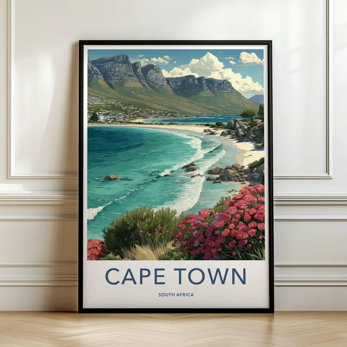 Framed travel poster of Cape Town's Table Mountain and coastal beach leaning against a white wall.