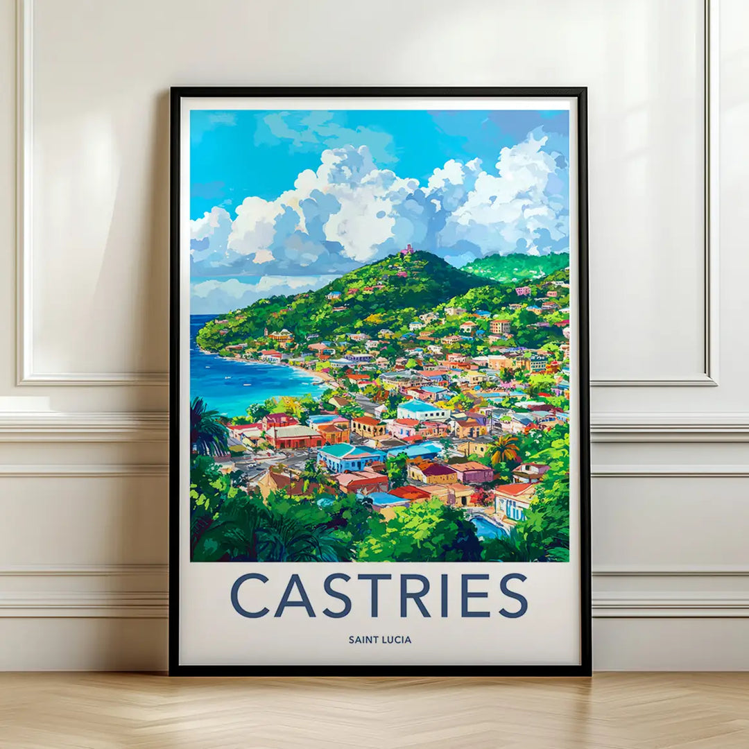 Framed travel poster of the colorful coastal town of Castries nestled in green hills by the sea leaning against a white wall.