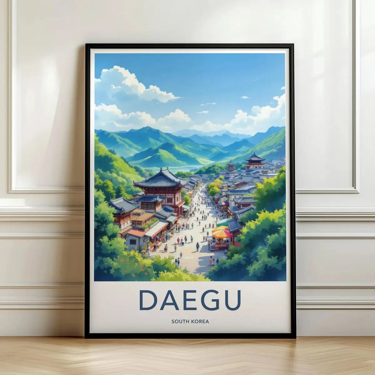 Framed travel poster of Daegu's traditional temples set against a mountain backdrop leaning against a white wall.