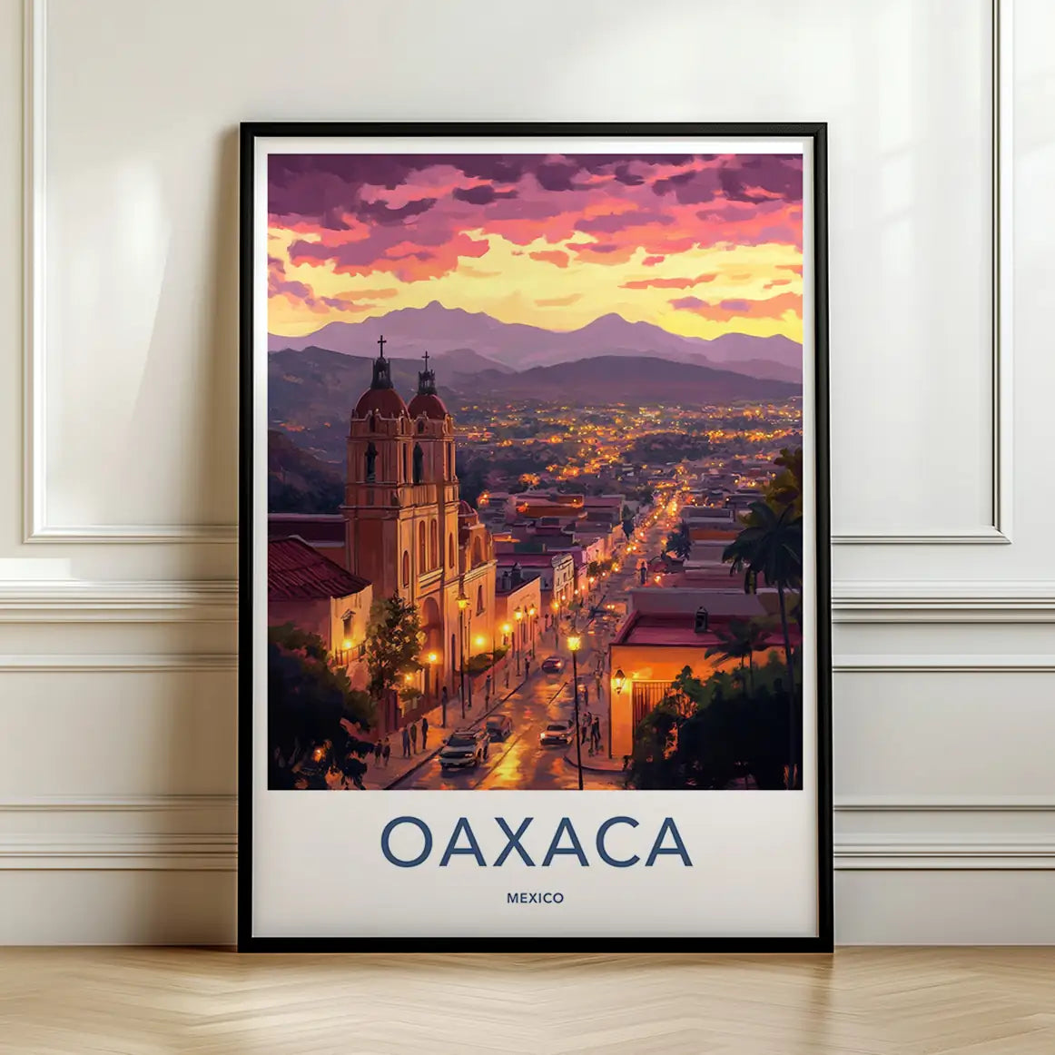 Framed travel poster of Oaxaca's city skyline and historic church at sunset leaning against a white wall.