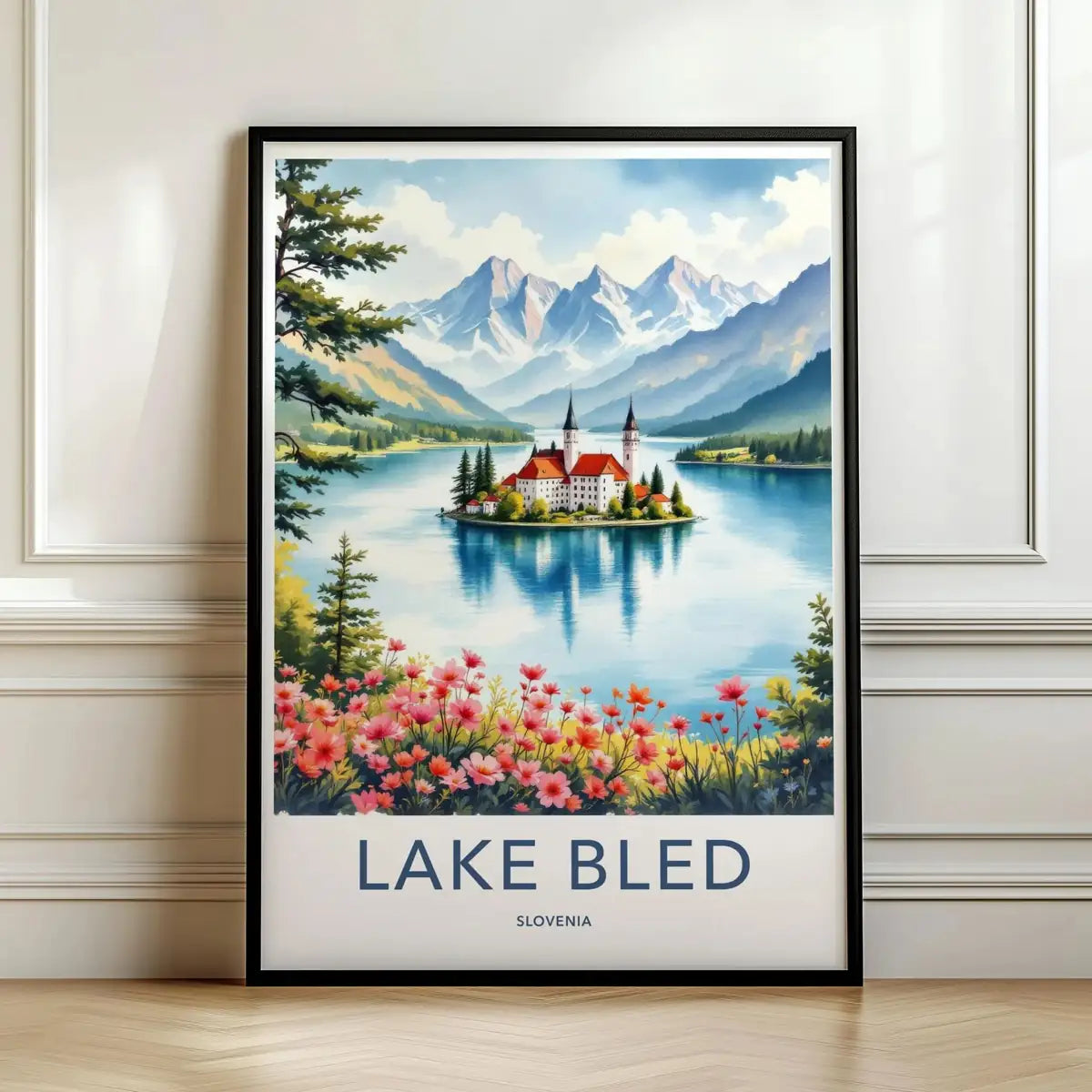 Framed travel poster of Lake Bled's island church surrounded by mountains leaning against a white wall.