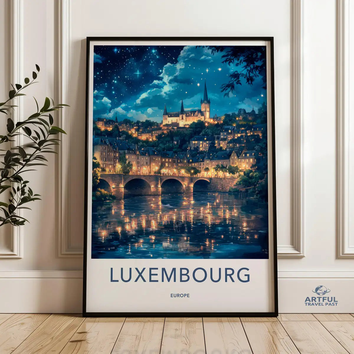 Framed travel poster of Luxembourg's historic cityscape, valley, and architecture leaning against a white wall.