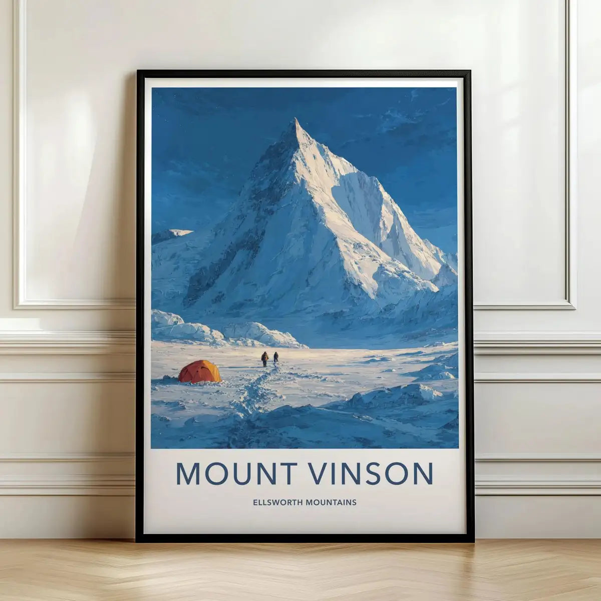 Framed travel poster of Mount Vinson's towering snowy peak and an orange expedition tent in a frozen landscape leaning against a white wall.