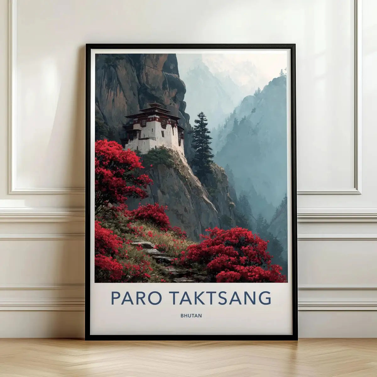 Framed travel poster of the Paro Taktsang monastery perched on a dramatic cliffside leaning against a white wall.