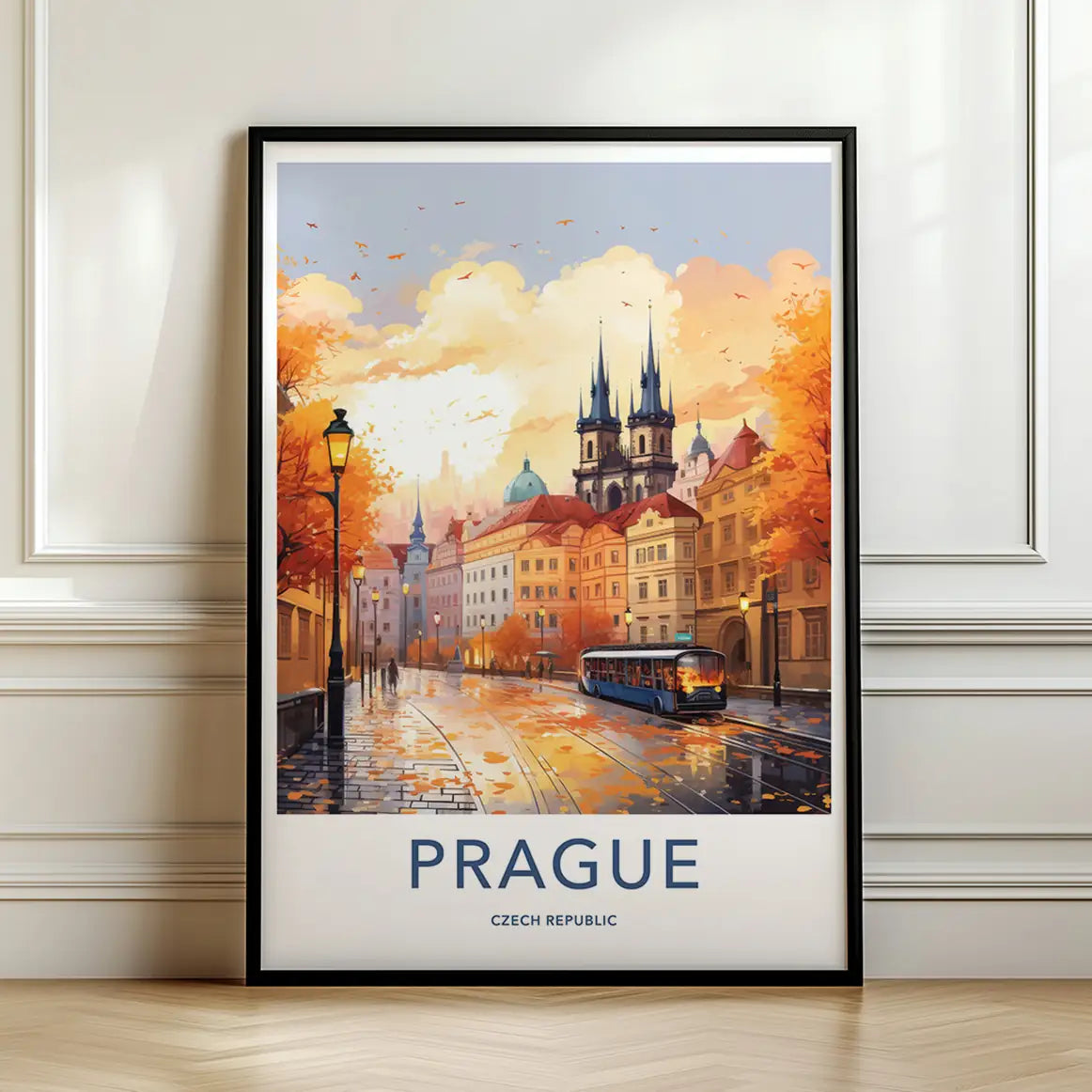 Framed travel poster of Prague's historic street, tram, and castle at sunset leaning against a white wall.