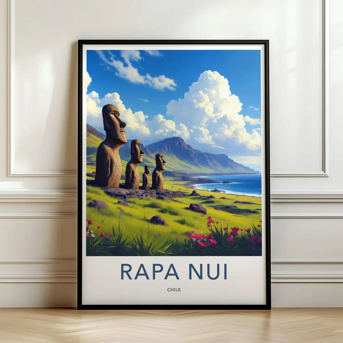 Framed travel poster of Rapa Nui's ancient Moai statues on a grassy coastal hill leaning against a white wall.