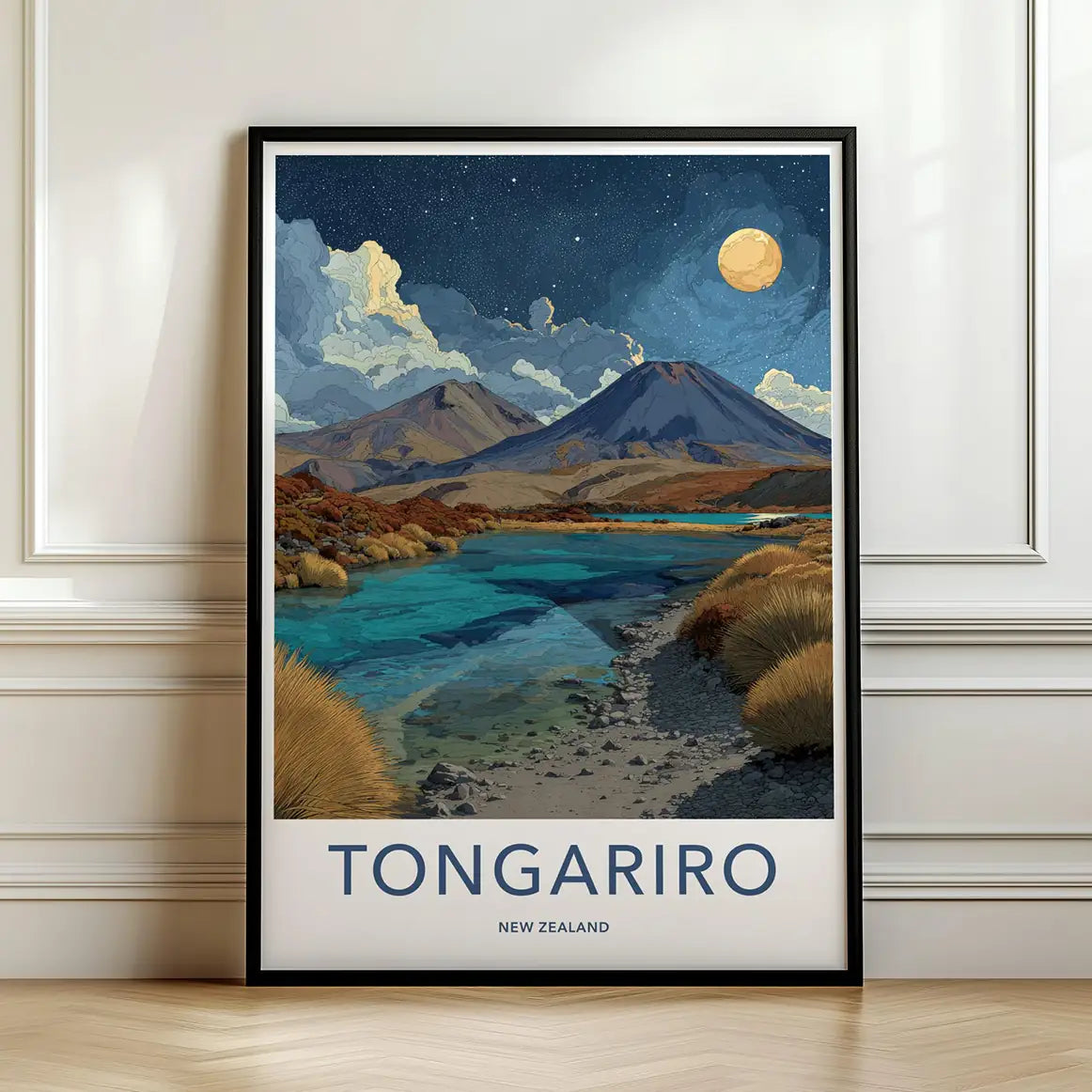 Framed travel poster of Mount Tongariro's volcanic landscape under a starry sky leaning against a white wall.