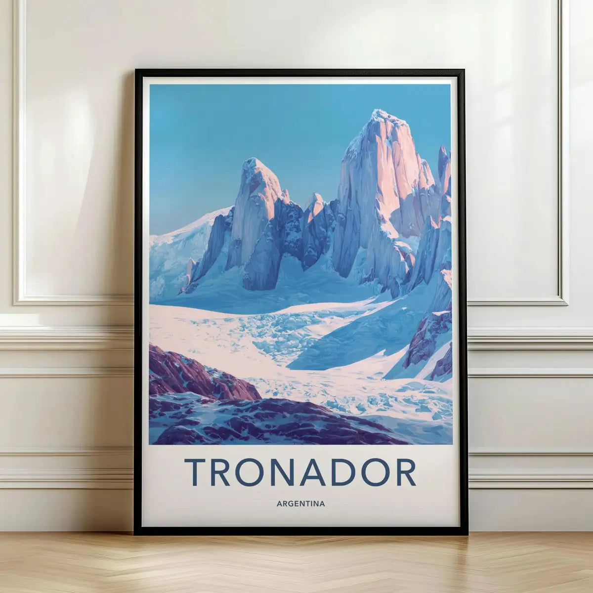 Framed travel poster of Mount Tronador's snowy peaks and glacier leaning against a white wall.