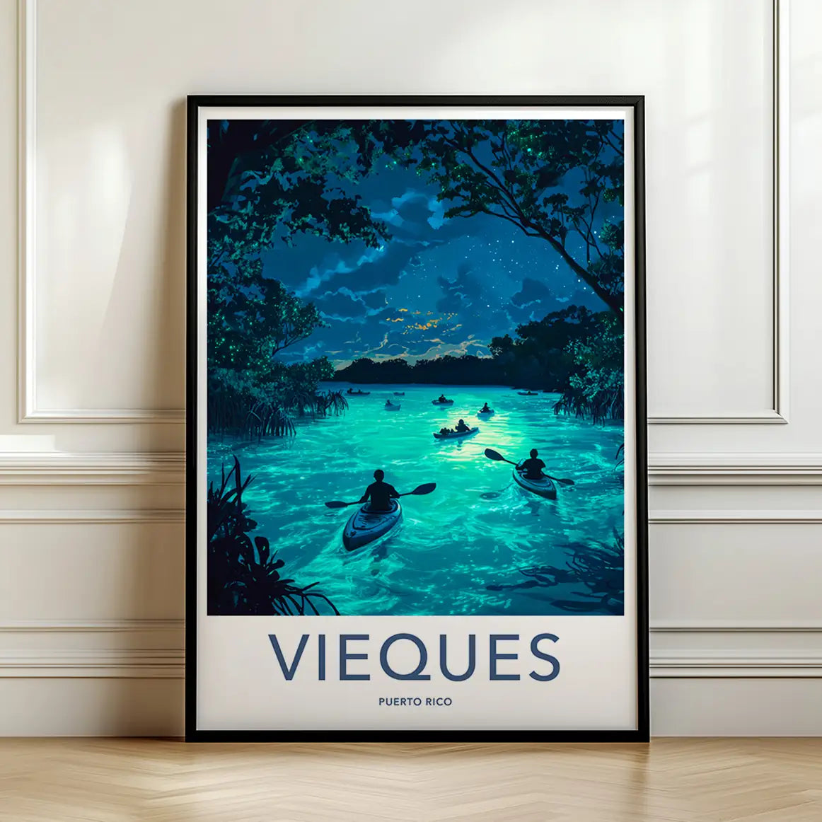Framed travel poster of a bioluminescent bay in Vieques with kayakers at night leaning against a white wall.