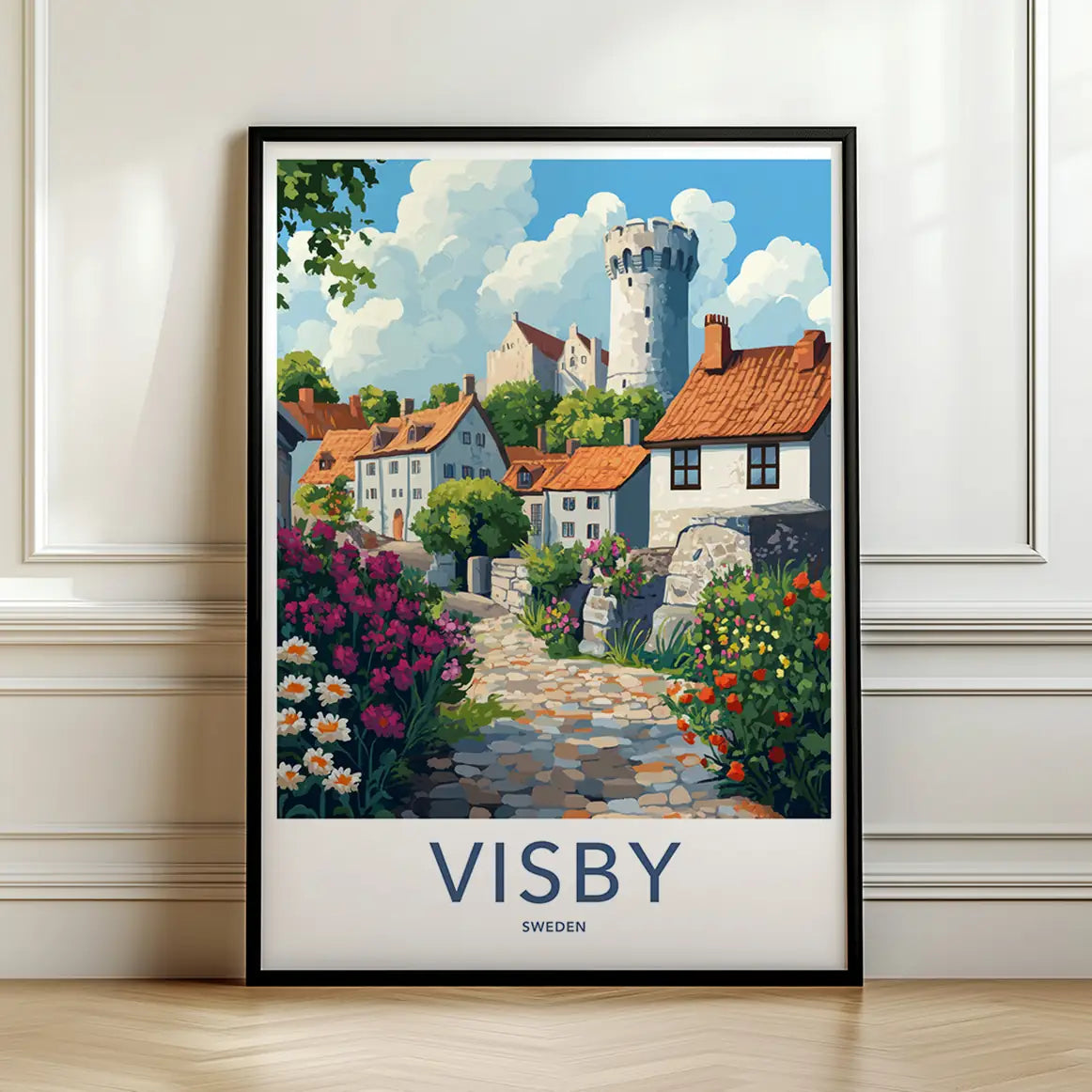 Framed travel poster of Visby's historic stone walls and coastal village leaning against a white wall.