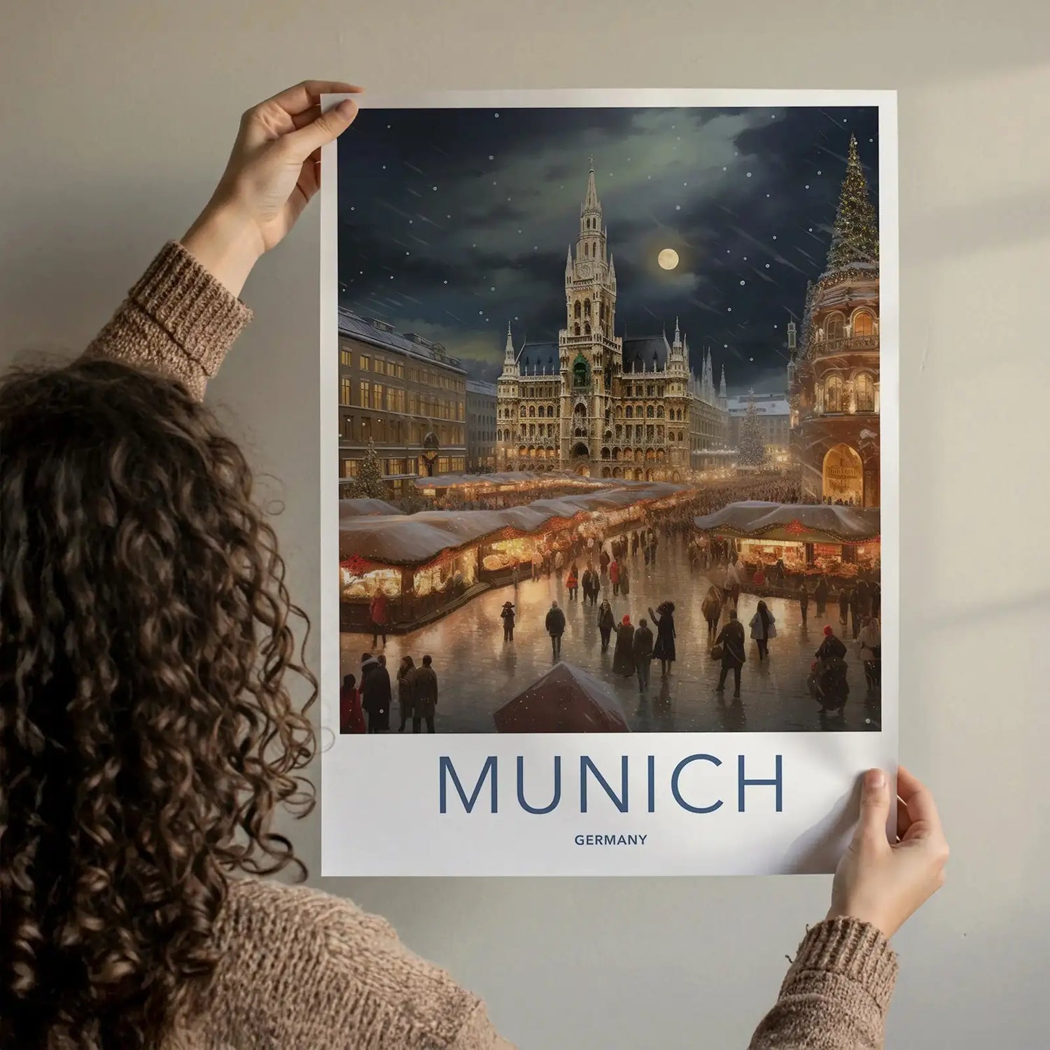 Person holding a framed Munich Christmas market travel poster.